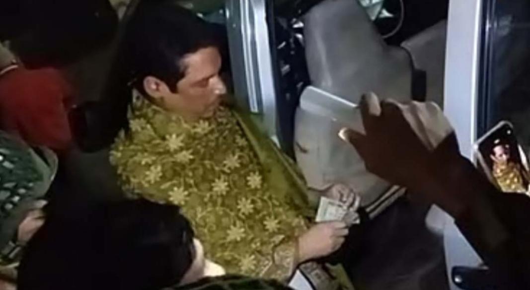 মাইক্রোবাসে এক ব্যক্তিকে টাকা গুনতে দেখা যায়